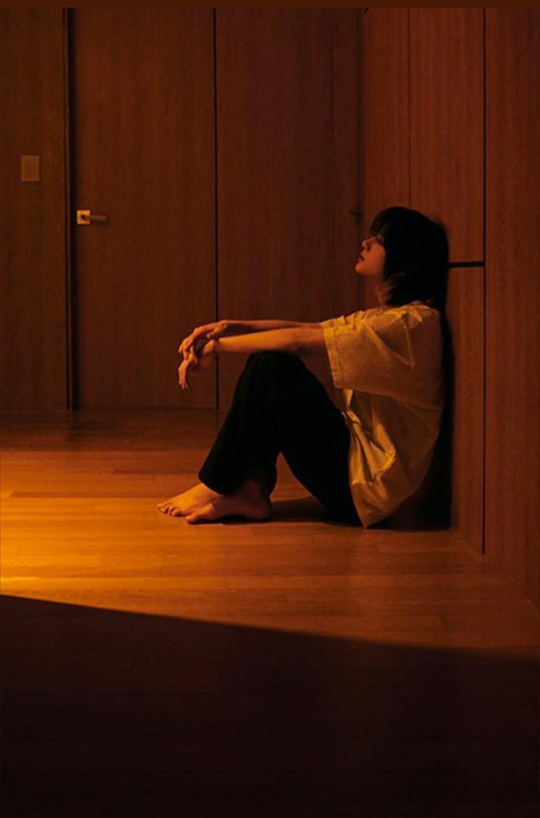 A person looking through a window on a rainy day, symbolizing hope and recovery.